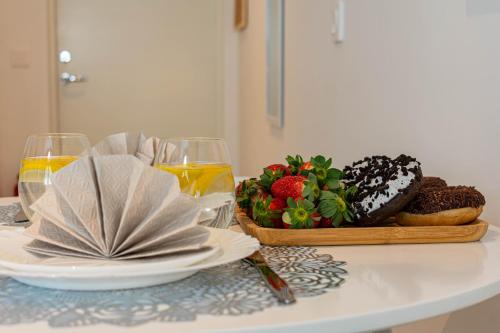 a table with a plate of doughnuts and a glass of orange juice at Apartments24 Spordi in Rakvere