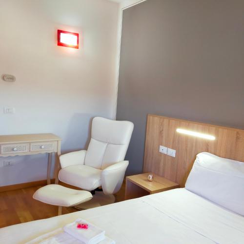 a room with two white chairs and a bed at Al Cavaliere in Pordenone
