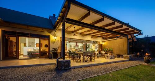 a house with a patio with a table and chairs at Kambaku River Lodge in Malelane
