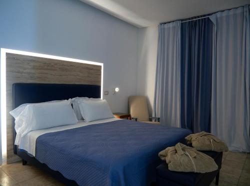 a bedroom with a large bed with a blue blanket at Saint Joseph in Salerno