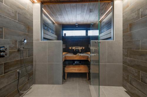 a bathroom with a shower with a desk and a sink at Luksushuvila Villa Marvik in Himos