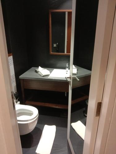 a bathroom with a toilet and a sink with a mirror at Country Inn & Suites by Radisson Chandigarh Zirakpur in Chandīgarh