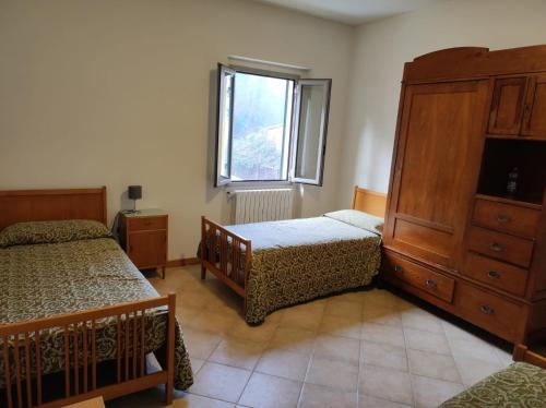 a bedroom with two beds and a dresser and a window at QOELET - B&B Etico e Sociale in Montevarchi