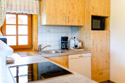 a kitchen with wooden cabinets and a sink at Gästezimmer Steiner in Gamlitz