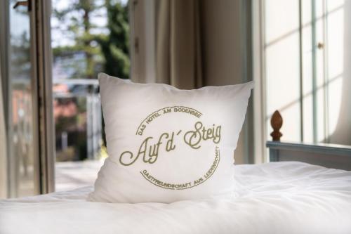 a white bed with pillows and pillows on it at Hotel Auf d´ Steig in Lindau
