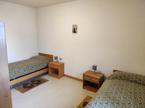 a bedroom with two beds and two night stands at QOELET - B&B Etico e Sociale in Montevarchi