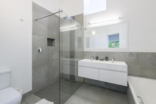 ein Bad mit einer Dusche, einem Waschbecken und einem WC in der Unterkunft San Lameer Villa 2603 - 4 Bedroom Superior - 8 pax - San Lameer Rental Agency in Southbroom
