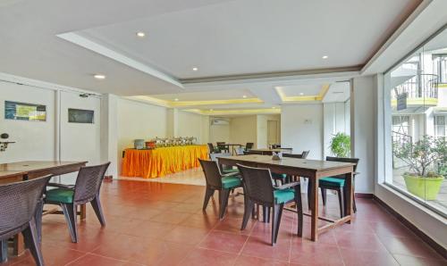 ein Esszimmer mit Tischen, Stühlen und einem Tisch in der Unterkunft Santa Monica Resort - Calangute in Calangute
