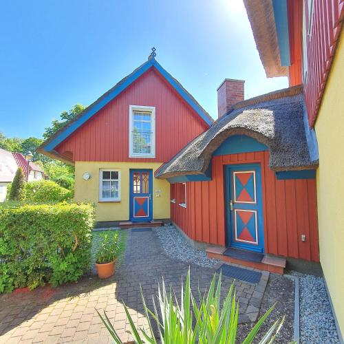 a red and yellow house with a red garage at "Kapitänshaus" by Ferienhaus Strandgut in Born