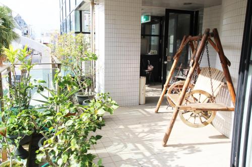 eine Schaukel auf der Veranda eines Hauses in der Unterkunft Hotel New Century in Okinawa