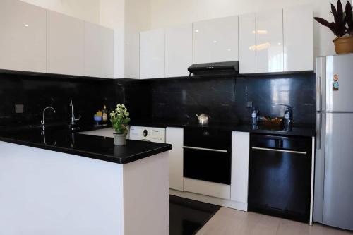 a kitchen with black counter tops and a white refrigerator at Guest Apartment in Baku