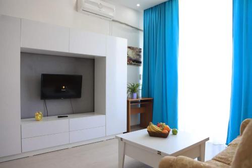 a living room with a tv on a wall at Guest Apartment in Baku