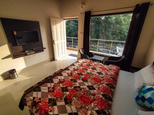 Un dormitorio con una cama con flores. en Anugraha Homestay, en Rāmnagar
