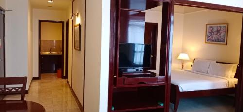 a hotel room with a bed and a tv in a mirror at Times Square Private Service Suite At KL in Kuala Lumpur