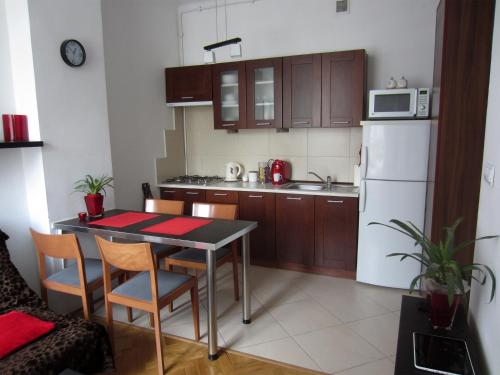 una pequeña cocina con mesa y nevera blanca en Unique Warsaw Center Apartment, en Varsovia