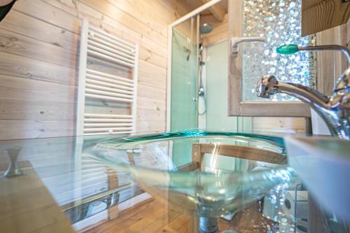a bathroom with a glass sink and a faucet at Dahu Wake Park, proche Saint Emilion in Sablons