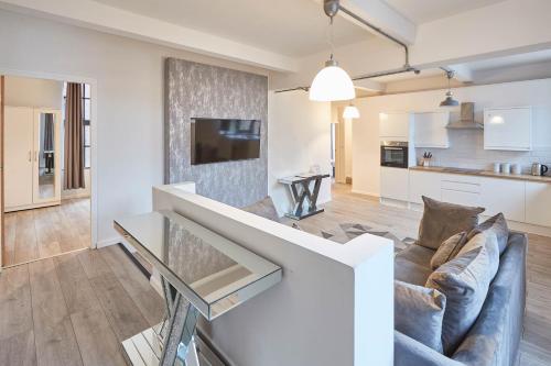 a living room and kitchen with a couch and a tv at Host & Stay - Concert Square in Liverpool
