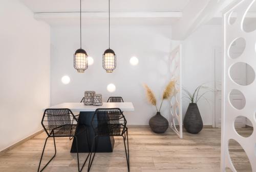 a dining room with a white table and chairs at Smy Mediterranean White Santorini in Kamari