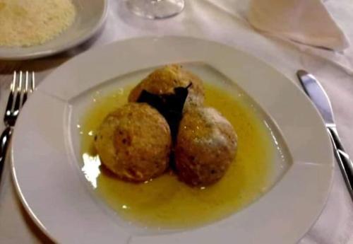 a white plate with two balls of food on a table at HOTEL BELVEDERE in Rivalta di Brentino