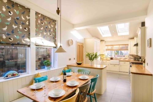 a kitchen with a wooden table and chairs in a kitchen at Sea Retreats, Whitley Bay, Sleeps 9 in Whitley Bay