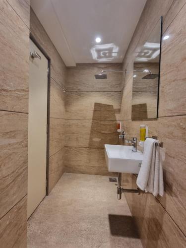 bagno con lavandino e specchio di Hotel El Magnifico a Surat