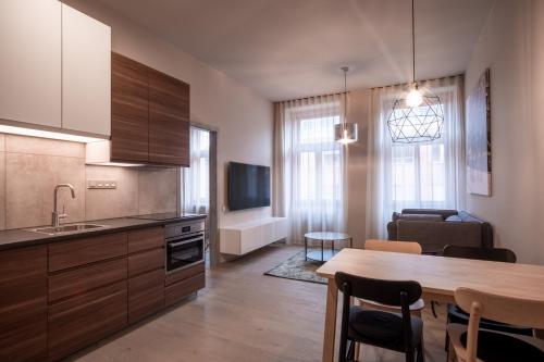 een keuken met een tafel en een eetkamer bij Aparthotel Rimska 14 in Praag