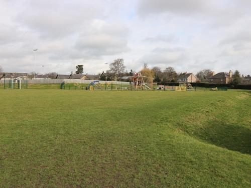 a large grassy field with a park with a playground at The Antlers in Coldstream