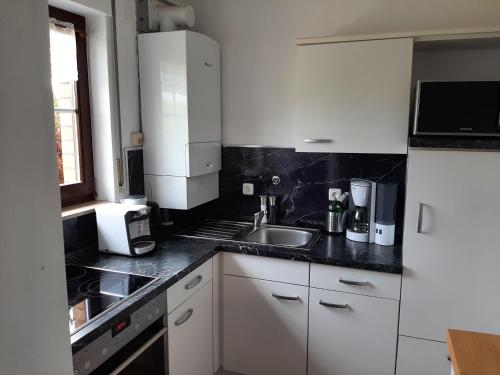 a kitchen with white cabinets and a sink at Beiboot in Wangerland