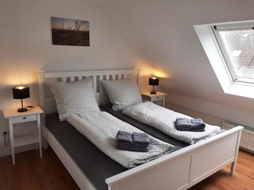 a bed with two pillows on it with two lamps at Beiboot in Wangerland