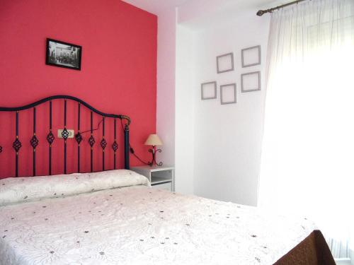 ein Schlafzimmer mit einer roten Wand und einem Bett in der Unterkunft Las Nereidas LEK in Peñíscola