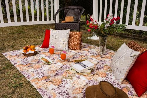 a picnic table with a book and fruit on a blanket at Country Inn Nature Resort Bhimtal in Bhīm Tāl
