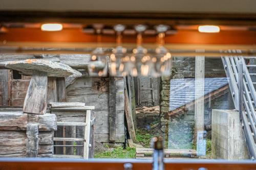 ein Fenster mit Blick auf eine Blockhütte mit einem Kronleuchter in der Unterkunft Bodmen 305 in Blitzingen