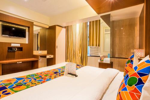 a hotel room with a bed and a television at FabHotel Spring inn - Nr Borivali Station in Mumbai