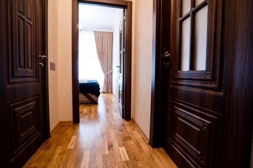 a hallway with two doors and a room with wood floors at Kristal Absheron in Baku