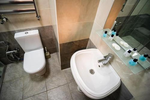 a bathroom with a white toilet and a sink at Kristal Absheron in Baku