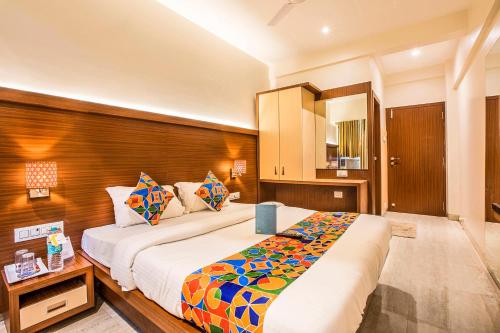 a bedroom with a large bed and a wooden wall at FabHotel Spring inn - Nr Borivali Station in Mumbai