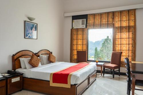 a bedroom with a bed and a large window at Country Inn Nature Resort Bhimtal in Bhīm Tāl