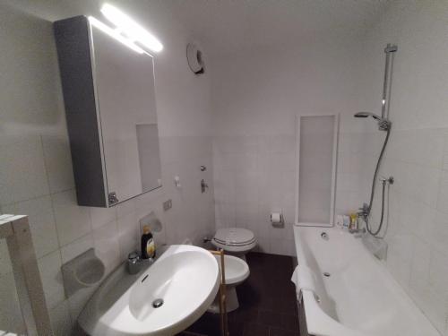 a bathroom with a sink and a tub and a toilet at PARK SIDE Apartment in Ponte di Legno