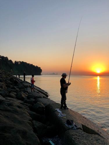 a man fishing on the beach at sunset at PAPILLON in Chakvi
