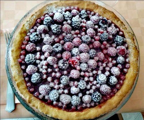 a pie with berries on top of it on a table at B & B La Mela in Darfo