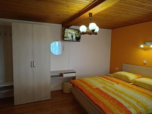 1 dormitorio con cama y techo de madera en Gostilna Pension Blegoš, en Poljane nad Škofjo Loko