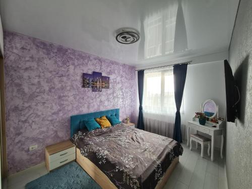 1 dormitorio con cama y pared púrpura en Adam and Eva Nest, en Năvodari