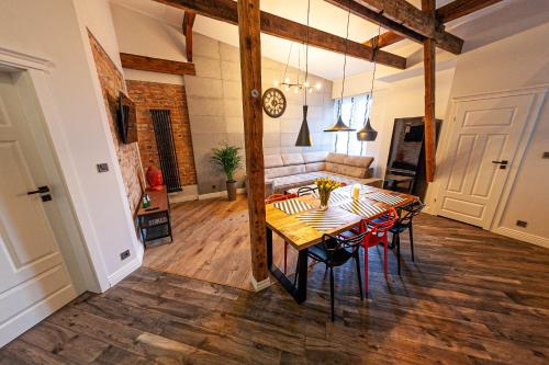 グダニスクにあるEuro Boho Loft Apartmentのテーブルとソファのあるダイニングルーム