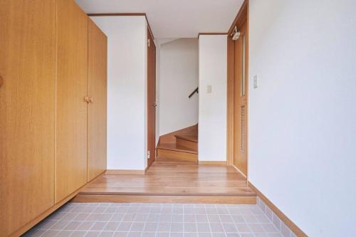 an empty hallway with wooden cabinets and a tile floor at 上落合ハウス KAMIOCHIAI HOUSE in Tokyo