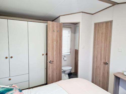 - une chambre avec des armoires blanches et des toilettes dans l'établissement Robin Hood's Retreat, à Robin Hood's Bay