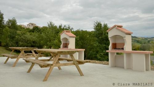a picnic table with a bird house and a bird feeder at Résidence L'Oustal Del Carlat in Carla-Bayle