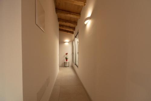 a hallway with a white wall and a flower in a pot at Domu Simius Hotel in Villasimius