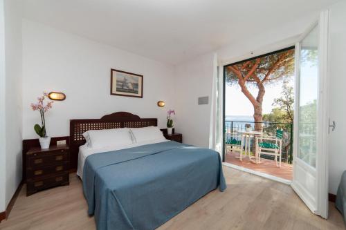 a bedroom with a bed and a view of the ocean at Hotel Antares in Capoliveri