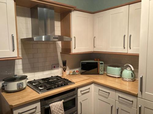 a kitchen with a stove top oven next to a microwave at Bedford House Retreat in Scarborough