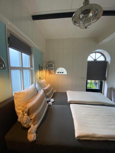 a room with two beds and a window at Het Koetshuis in Kamperland